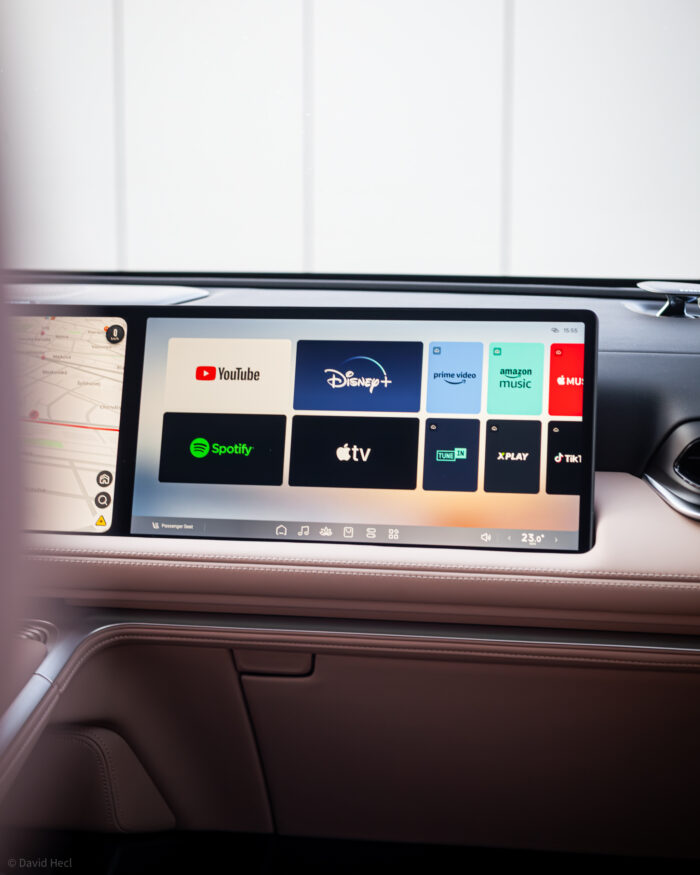 Autobazar.EU | Aj pred spolujazdcom je 15-palcový displej. Ten slúži skôr na zábavu, ale umožňuje aj základné nastavenia polohy sedadla, audio sústavy či iných základných funkcií. Jeho krycie sklo má navyše polarizáciu, takže z miesta vodiča len ťažko vidím, čo môj spolujazdec pozerá. Ak si však pustí nejaké video, zvuk je počuť normálne.